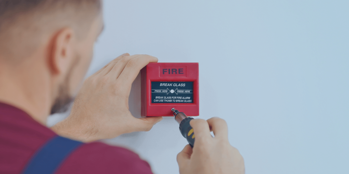 homem configurando acionador de alarme de incendio