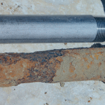 tubo galvanizado ao lado de um tubo enferrujado