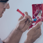 homem instalando os fios de conexão do acionador de alarme