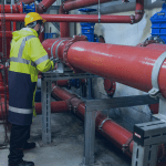 homem vestindo EPI para fazer a manutenção de tubos hidráulicos para incendio